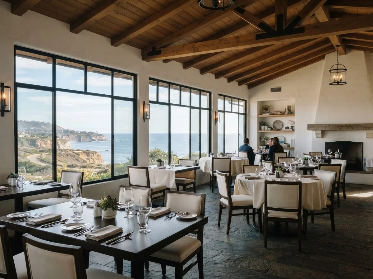 A renovated restaurant dining room with timber ceilings and a view of the ocean